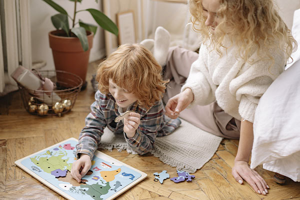 Photo of a mother and son doing a puzzle together and laughing. ADHD and autism evaluations in Texas can help you reach a diagnosis and open the door for support in school and life.